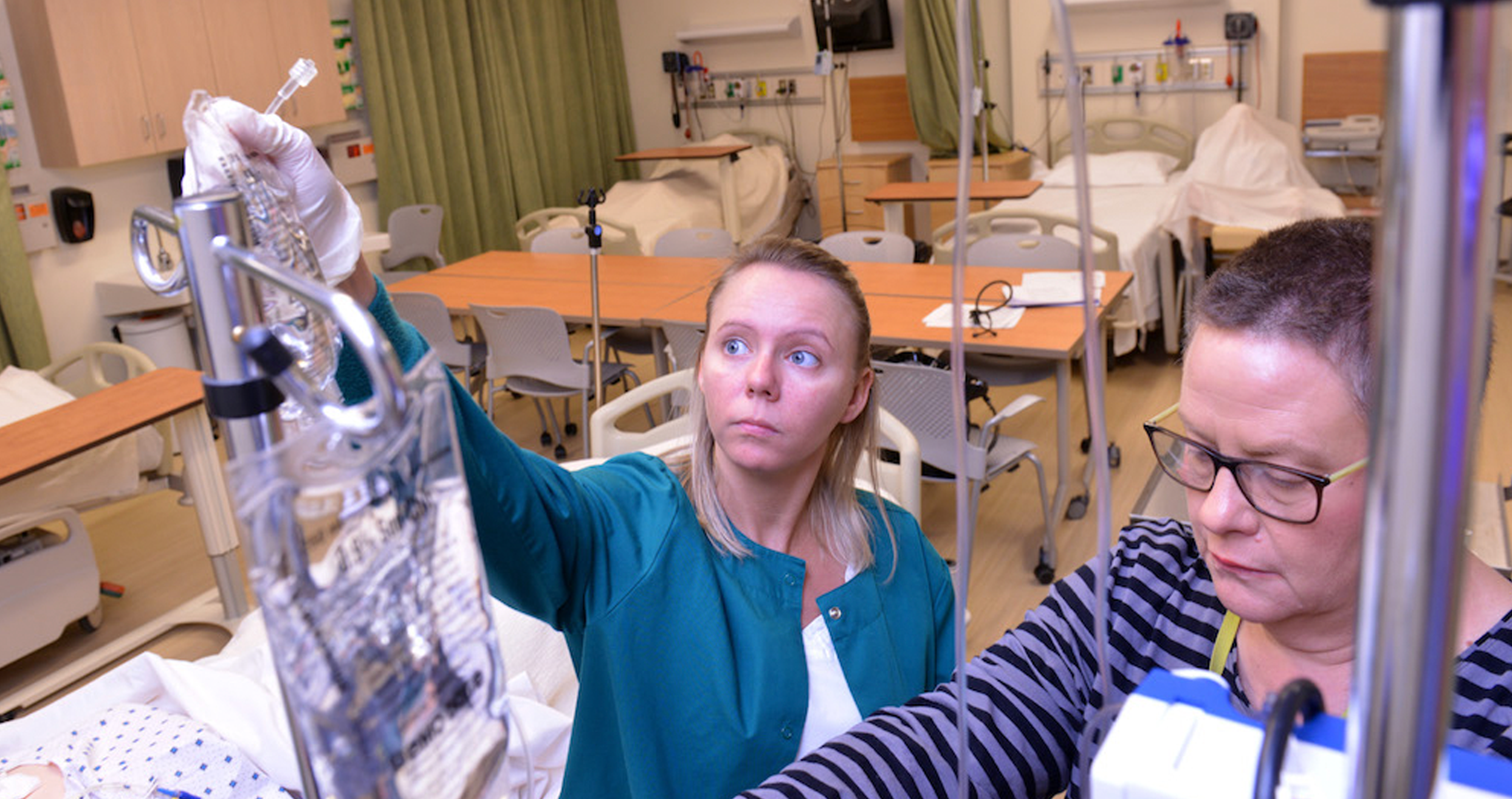 Two health students adjusting an IV